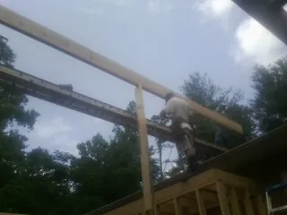 Carpenter setting a ridge beam over a new addition frame — Ice Dam Removal by Roofing Brothers in White Plains